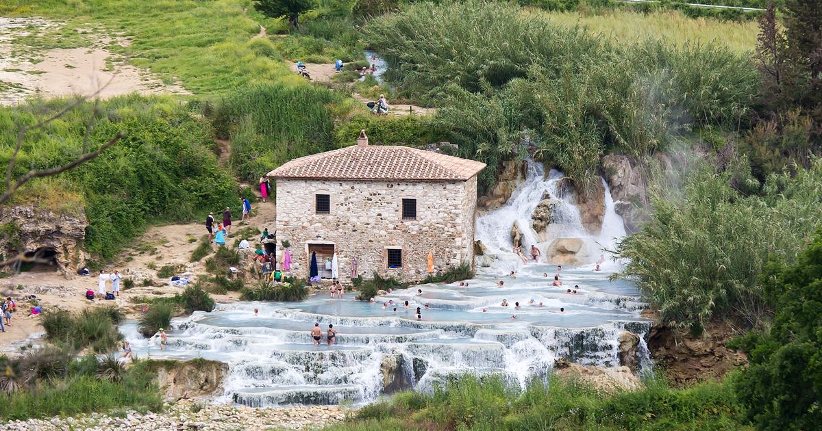 Le vasche termali bianche delle Cascate del Mulino di Saturnia con il vecchio mulino